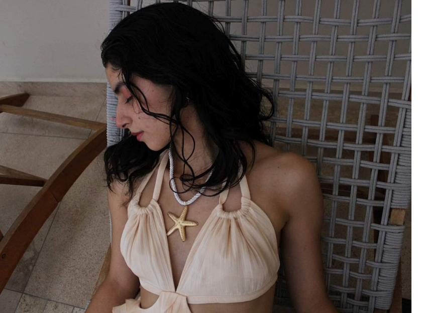 Detalle de collar de estrella de mar sobre vestido marfil